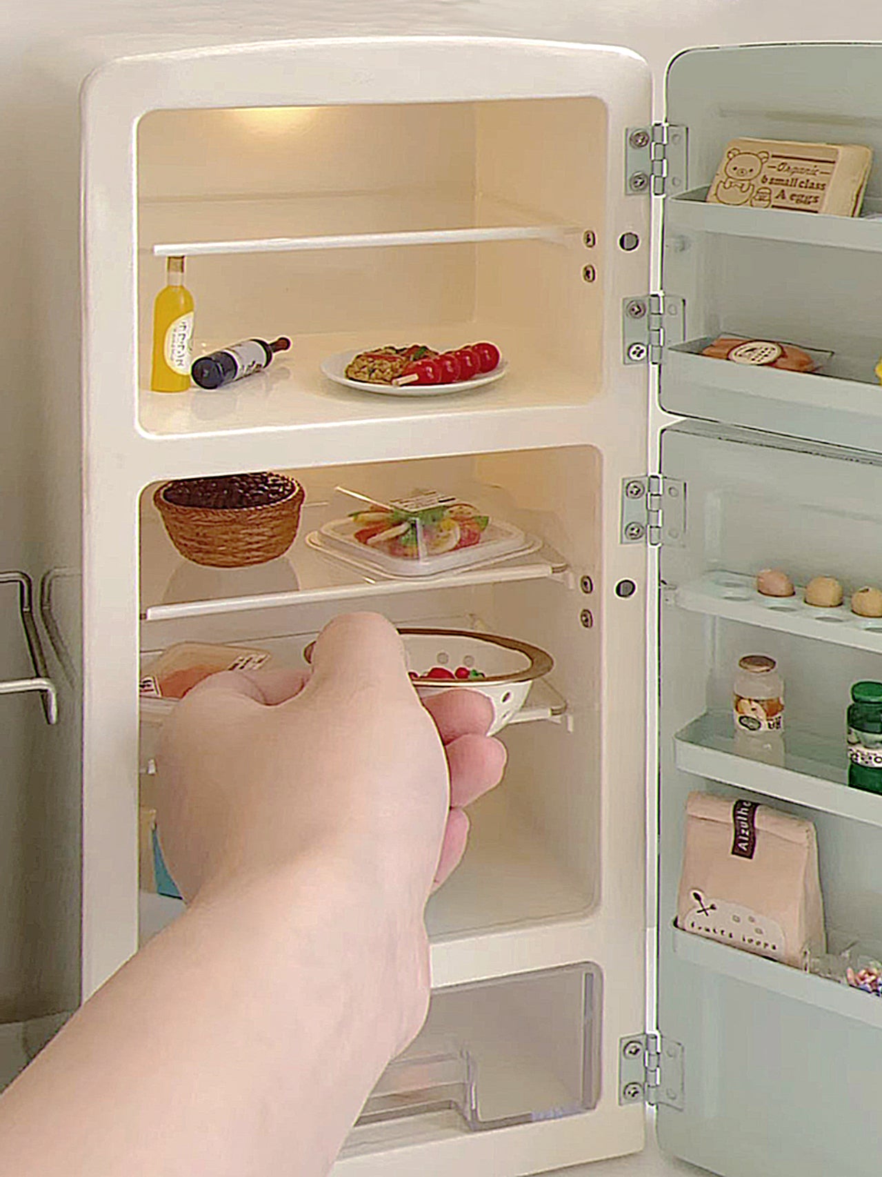 Close view of open mint green dollhouse refrigerator with lit shelves, door racks and food props not included