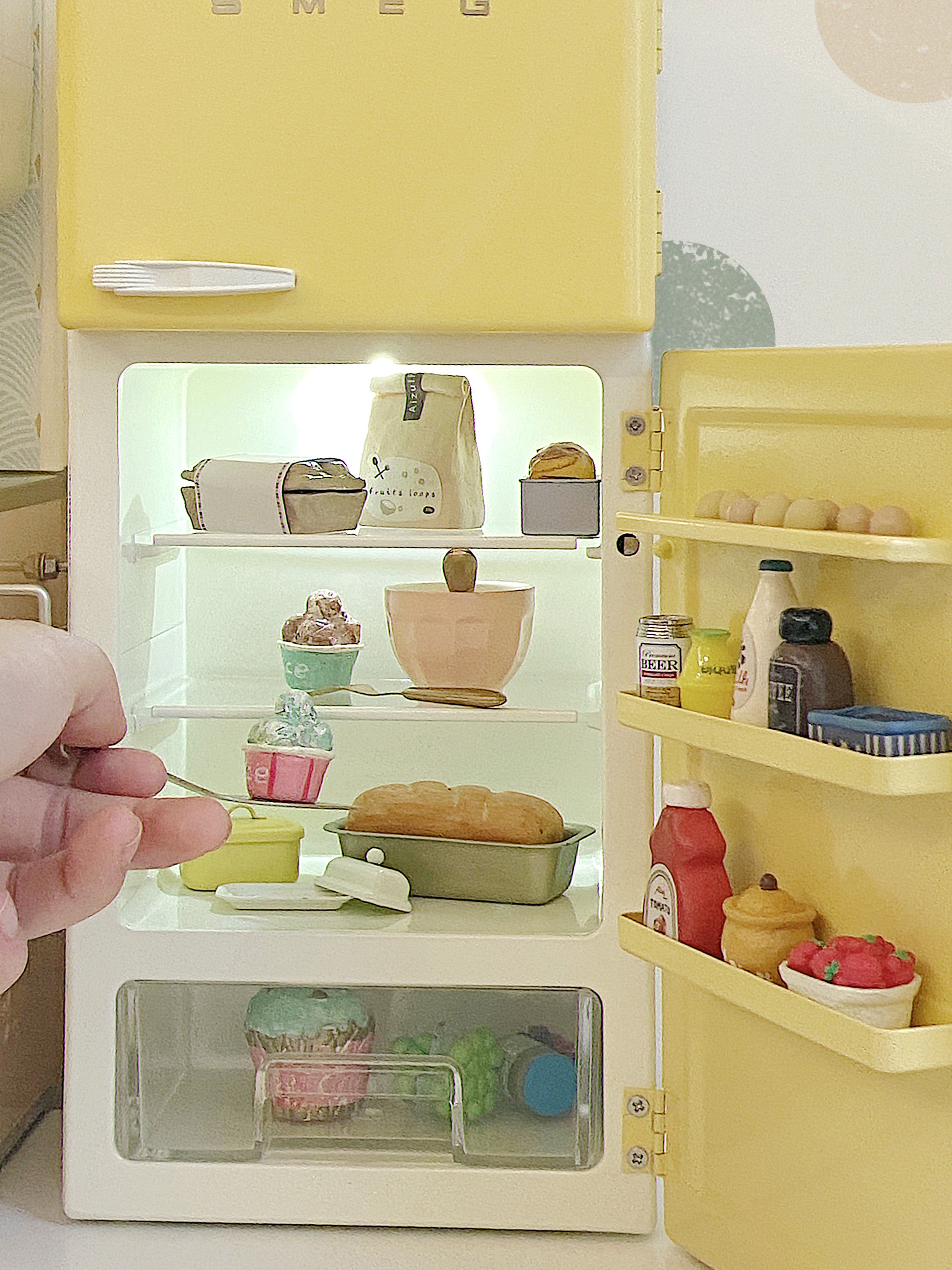 Open yellow 1:6 dollhouse refrigerator with lit shelves, drawer, door racks and miniature food props