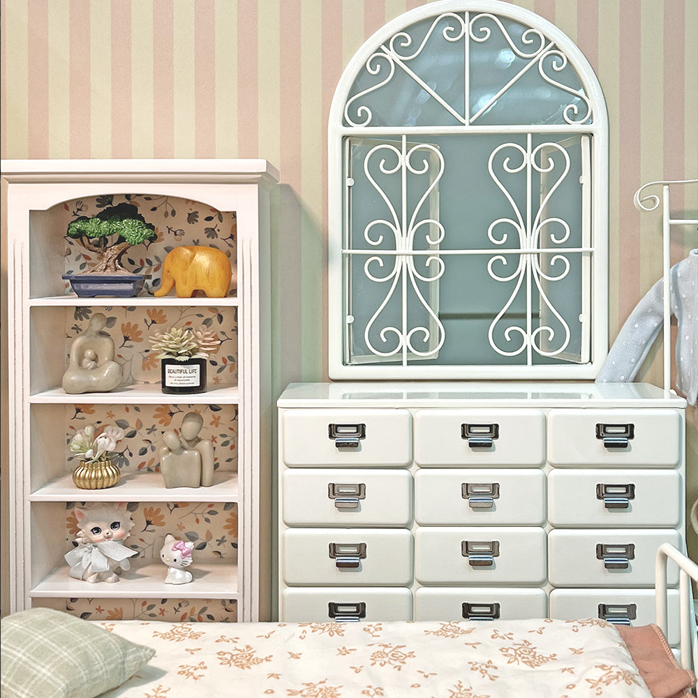 Off-white miniature drawer chest styled in a dollhouse bedroom with window and display shelf