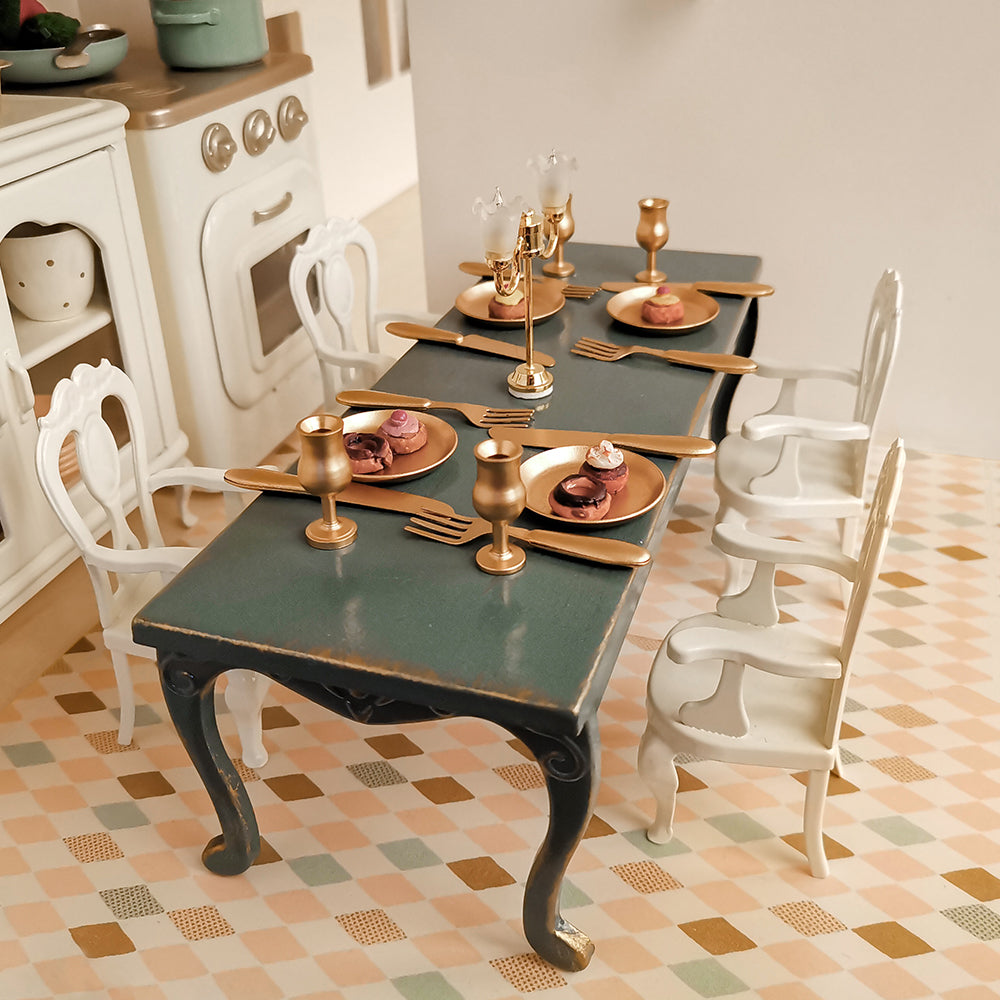 White Princess Chairs styled with dark green long table and miniature dinnerware in a 1:12 dollhouse kitchen