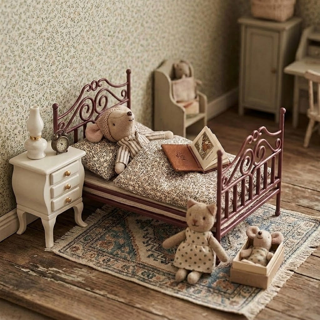 Red dollhouse antique bed styled in a Maileg Micro-style bedtime room with lamp, book and toys
