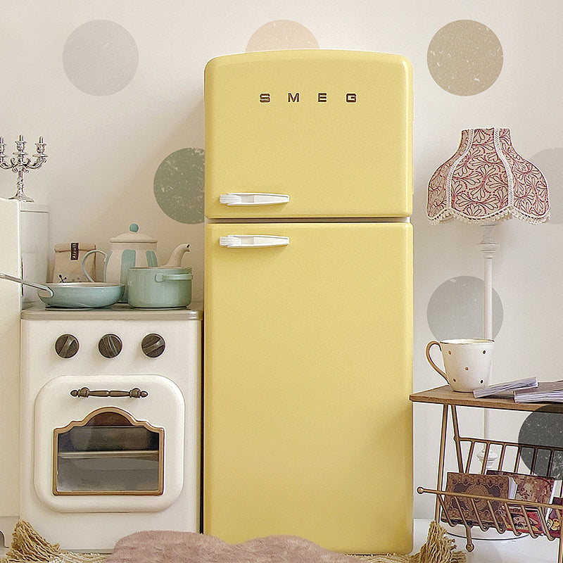 Closed yellow dollhouse refrigerator in a kitchen scene with oven, lamp, shelf and room props not included